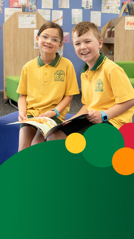 Students smiling together in the library at St Mary MacKillop Primary School South Penrith