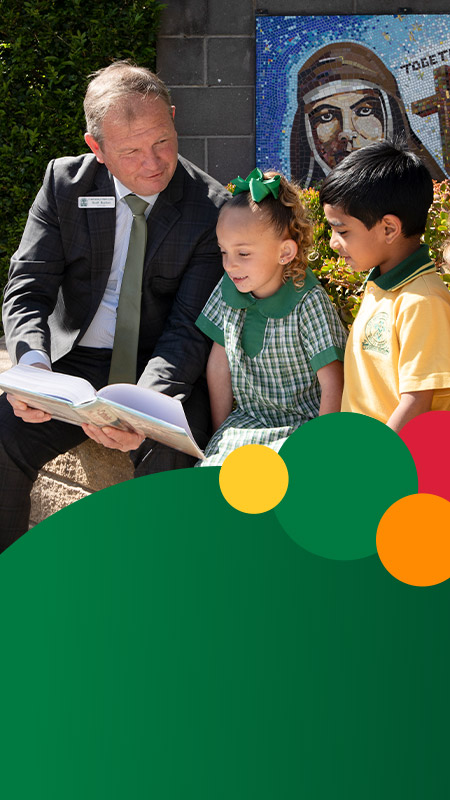 Principal Scott Buchan of St Mary MacKillop Primary School South Penrith with his students on the school grounds