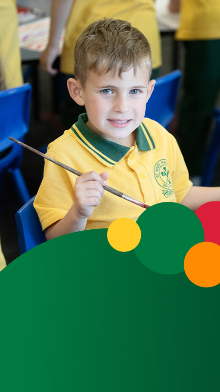 Student painting in the classroom at St Mary MacKillop Primary School South Penrith