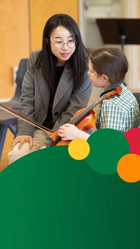 Student learning to play the violin from her teacher at St Mary MacKillop Primary School South Penrith