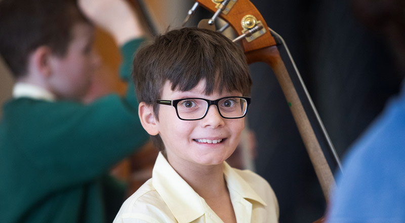 Student learning to play the cello in the classroom at St Mary MacKillop Primary School South Penrith