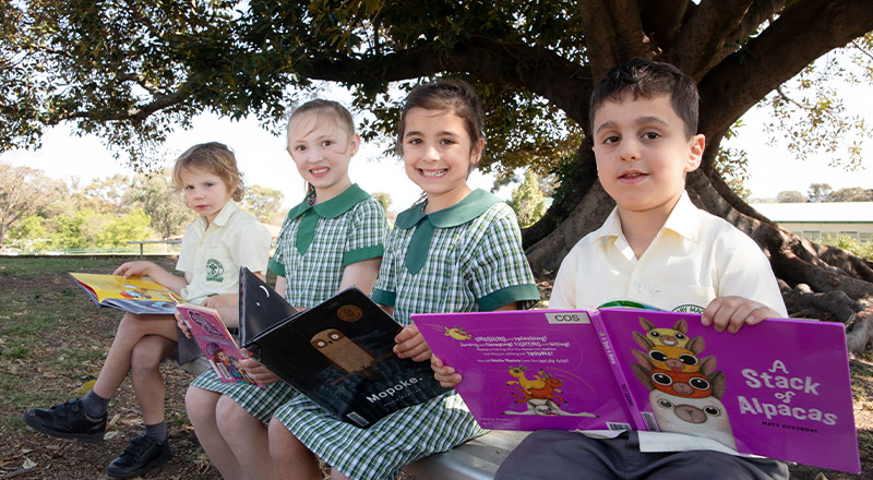 Students reading outside at St Mary MacKillop Primary School South Penrith