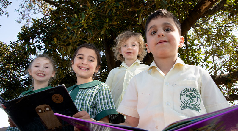Students reading outside togther at St Mary MacKillop Primary School South Penrith