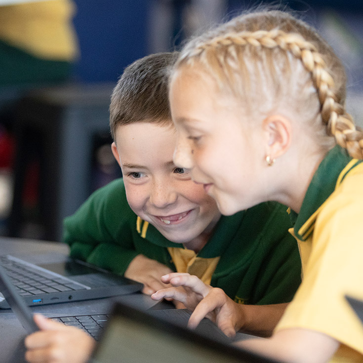 Students smiling together in the classroom at St Mary MacKillop Primary School South Penrith