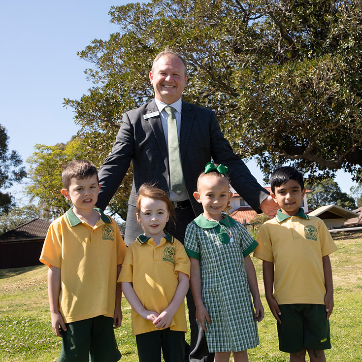 Principal Scott Buchan of St Mary MacKillop Primary School South Penrith with his students on the school grounds