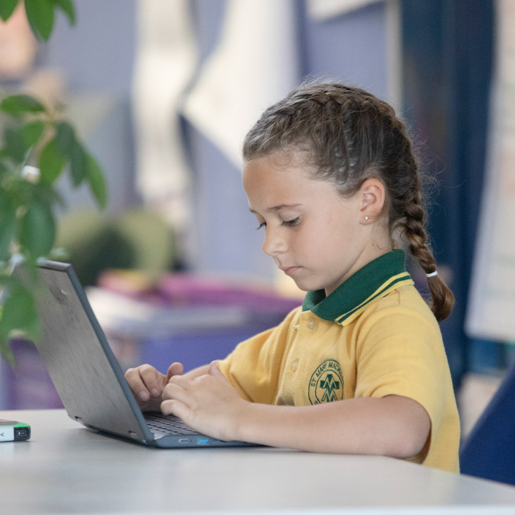 Student working on her laptop in the classroom at St Mary MacKillop Primary School South Penrith