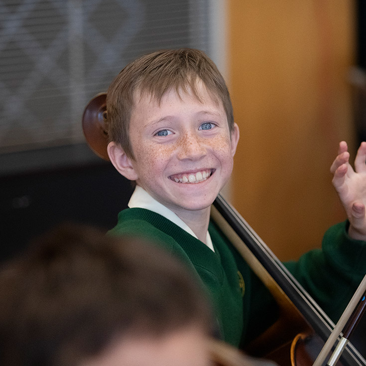Student learning to play the cello in the classroom at St Mary MacKillop Primary School South Penrith