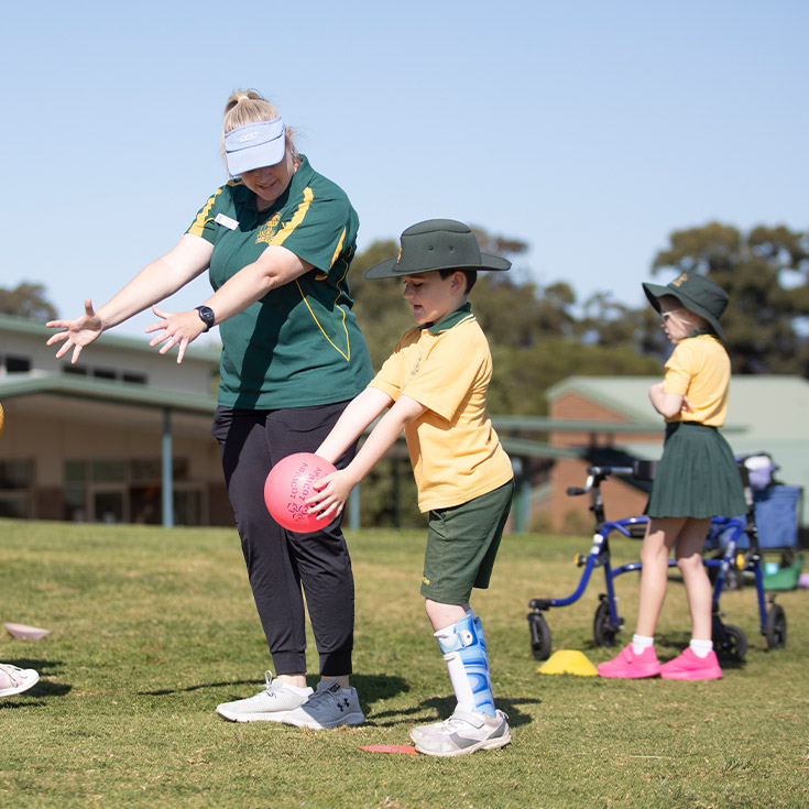 Teacher assisting her student on the playground at St Mary MacKillop Primary School South Penrith